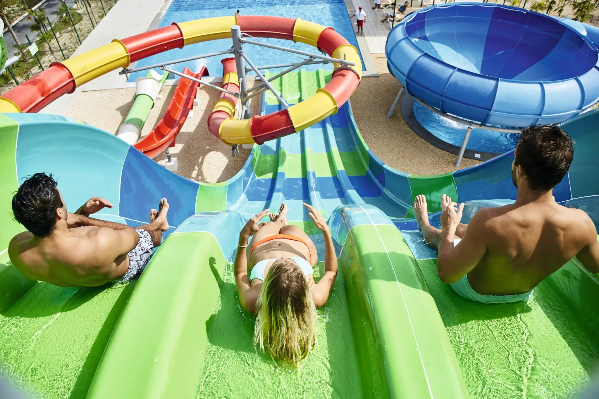Guests racing down colorful slides at Splash Water World at neighboring Riu Dunamar